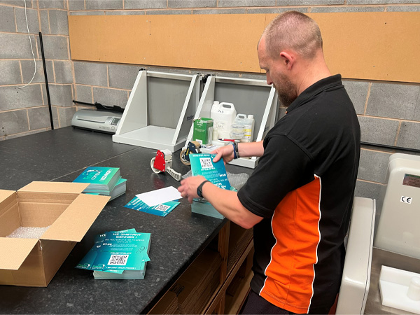 Team member Gary instpecting the quality of printed folded leaflets before delivery.